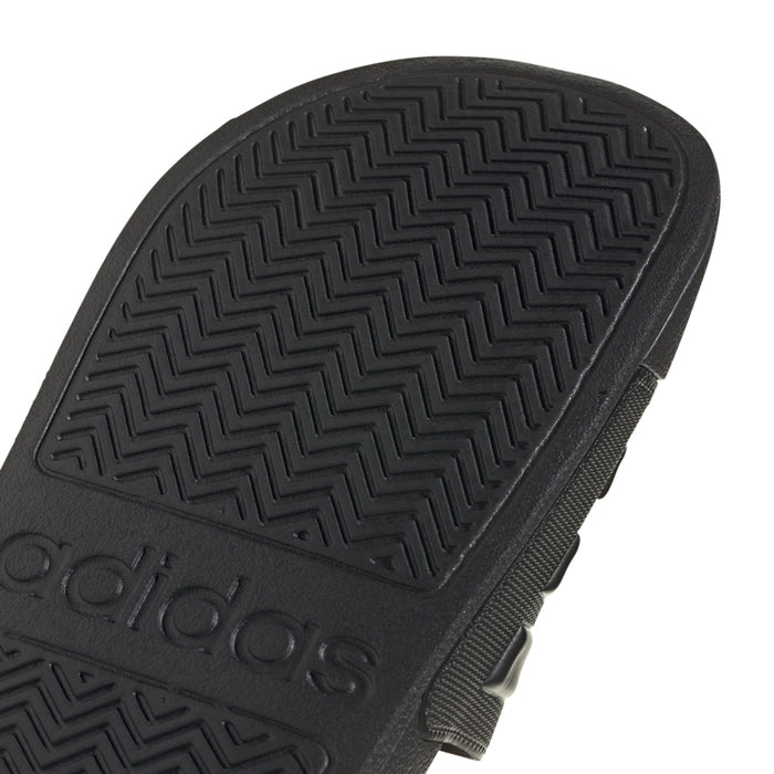 Black rubber outsole close-up with zigzag tread and adidas logo
