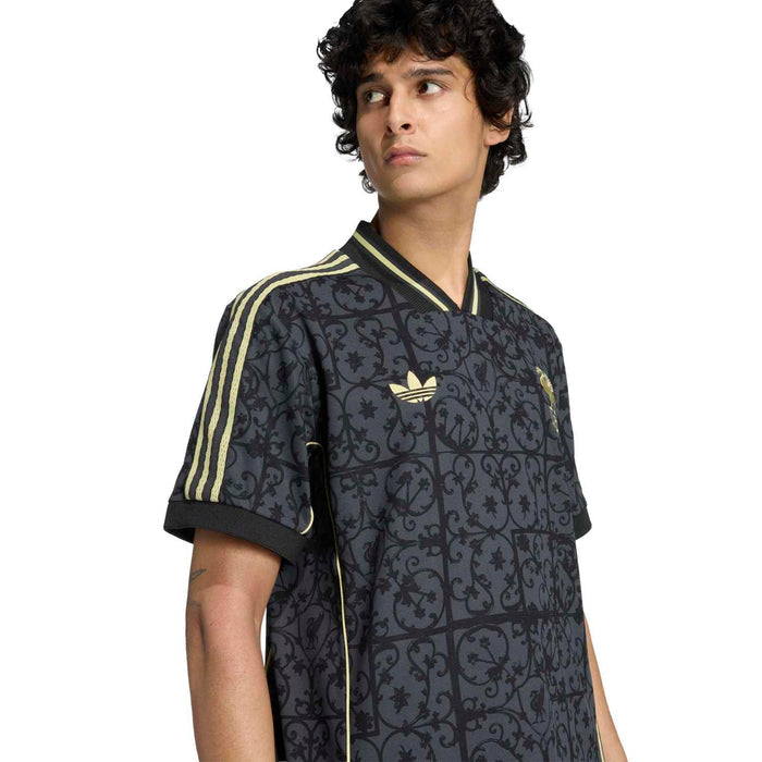 Men's navy Liverpool jersey close-up with gold collar trim and LFC crest on the chest.