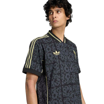 Men's navy Liverpool jersey close-up with gold collar trim and LFC crest on the chest.