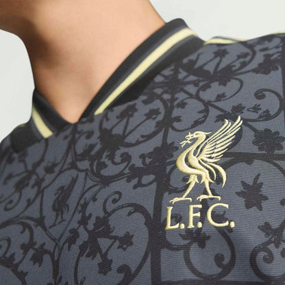 Men's navy Liverpool jersey neckline and crest close-up with gold accents and pattern.