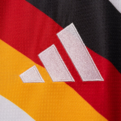 Adidas three-stripe logo on white jersey with red and gold diagonal accents