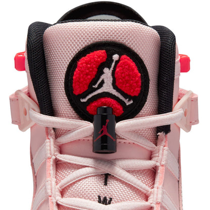 Close-up of pink sneaker heel with black circular patch and red Jumpman graphic