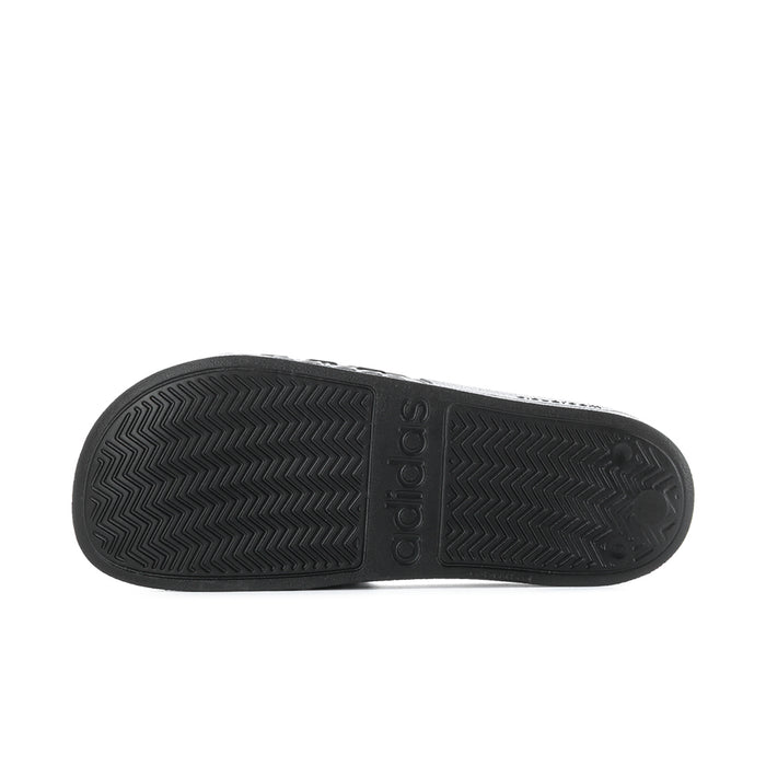 Black slide sandal outsole with chevron tread pattern and adidas logo