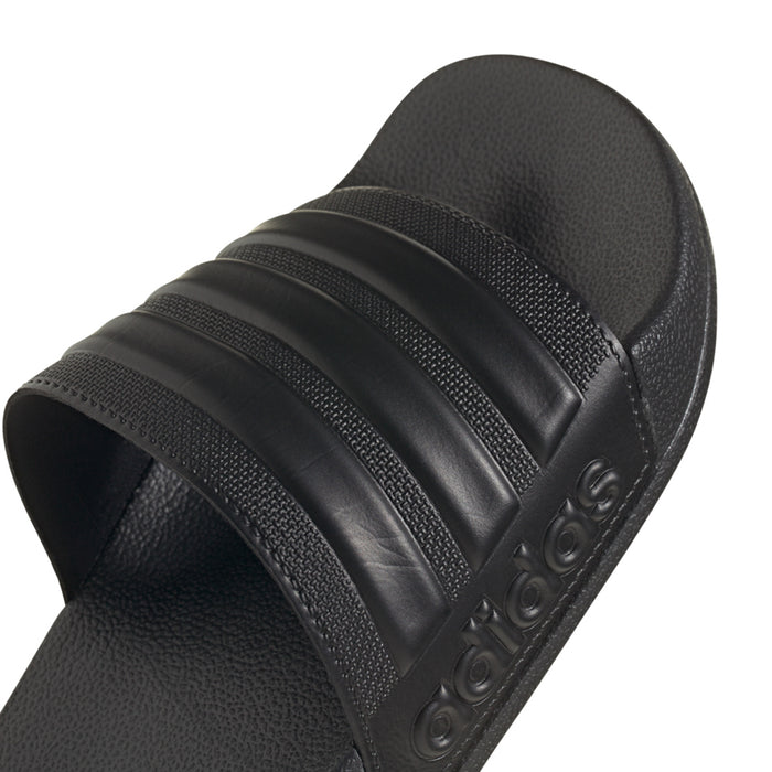 Black adidas slide sandal upper close-up with three strap bands and embossed logo