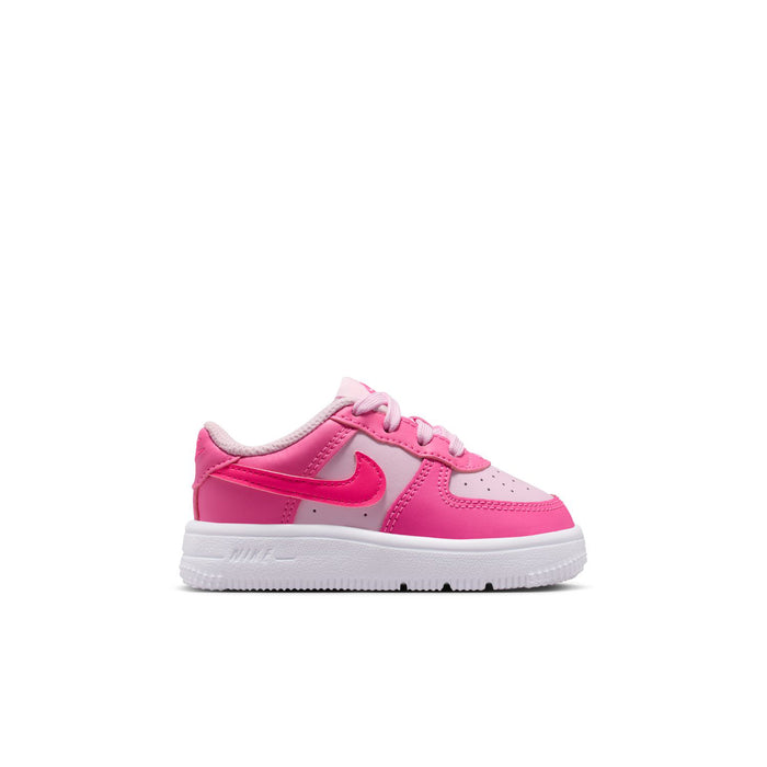 Toddler Nike Air Force 1 low-top sneakers in pink and white, side view with swoosh