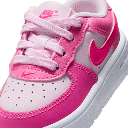 Toddler Nike Air Force 1 sneaker close-up, pink laces and swoosh on white vamp