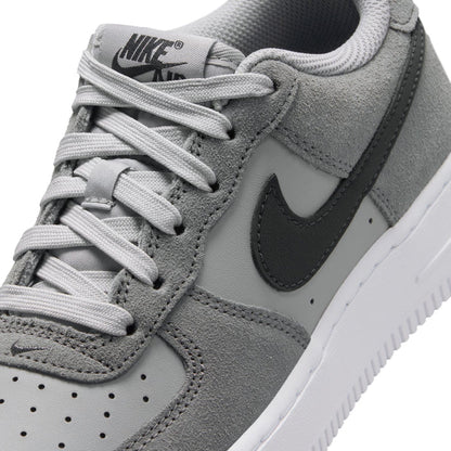 Youth Air Force 1 sneakers, close-up, smoke gray suede with white laces and Nike logo