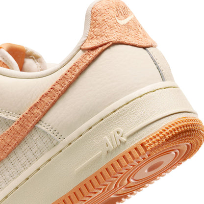 Women’s Air Force 1 side close-up with orange swoosh and textured gum sole edge.