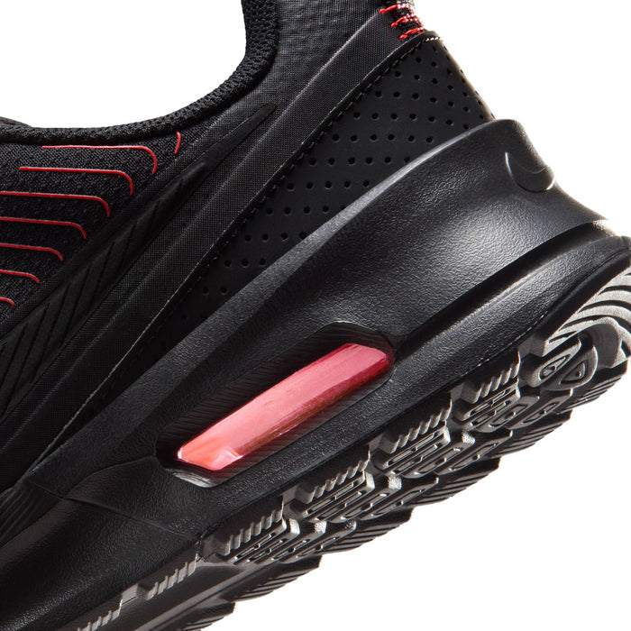 Close-up men's black sneaker side with red/black lines and pink Air window