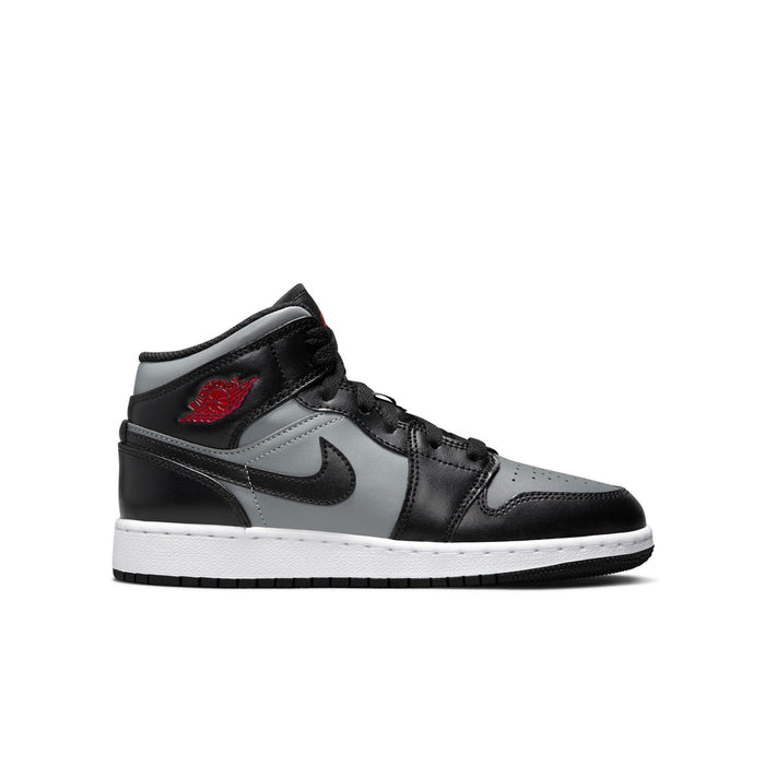Youth mid-top sneakers in black with gray panels, white sole, and red accent logo