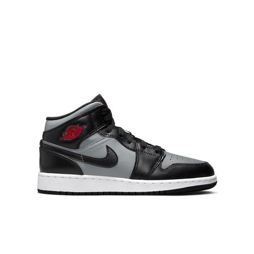Youth mid-top sneakers in black with gray panels, white sole, and red accent logo