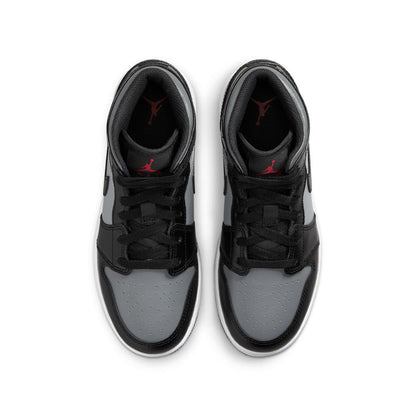 Pair of youth mid-top sneakers showing toe and laces; black, gray, white with red lining