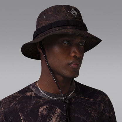 Dark brown/olive bucket hat with compass emblem and black wraparound band