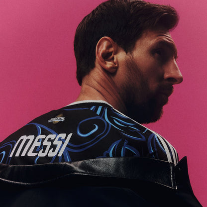 Black jersey shoulder close-up with blue swirls and white MESSI text