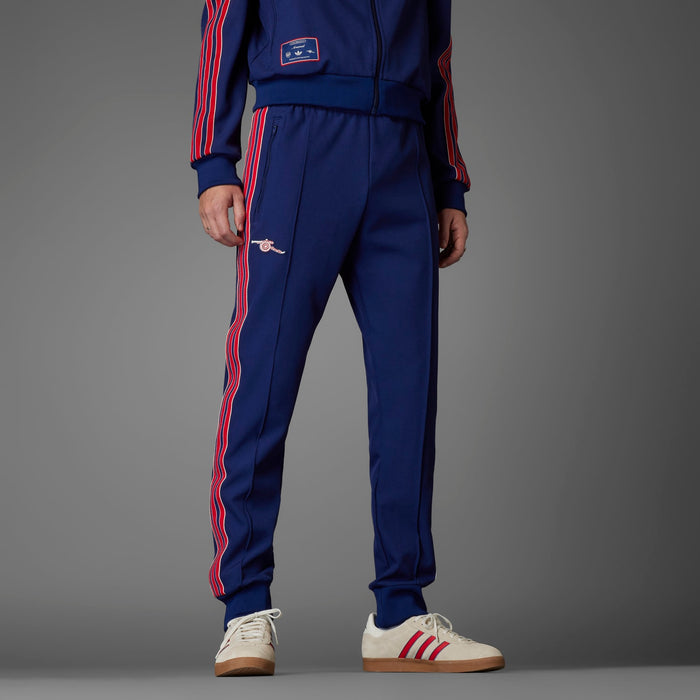 Men’s blue track pants with red and white side stripes, elastic cuffs