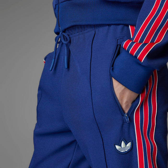 Blue track pants with drawstring waistband and adidas-style trefoil logo