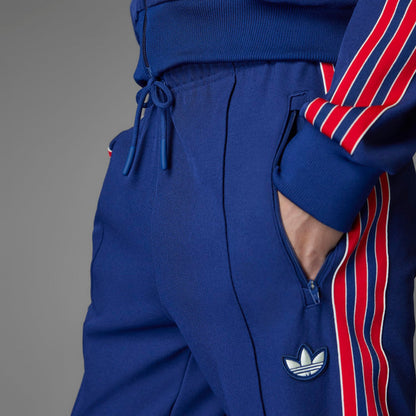 Blue track pants with drawstring waistband and adidas-style trefoil logo