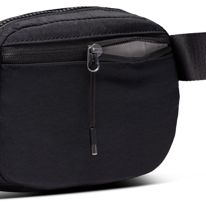 Close-up of black crossbody bag zipper with metal pull tab and textured trim
