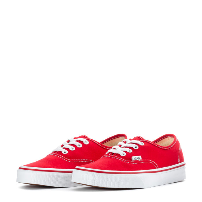 Pair of youth red low-top sneakers with white laces and VANS patch on tongue