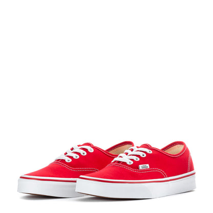Pair of youth red low-top sneakers with white laces and VANS patch on tongue