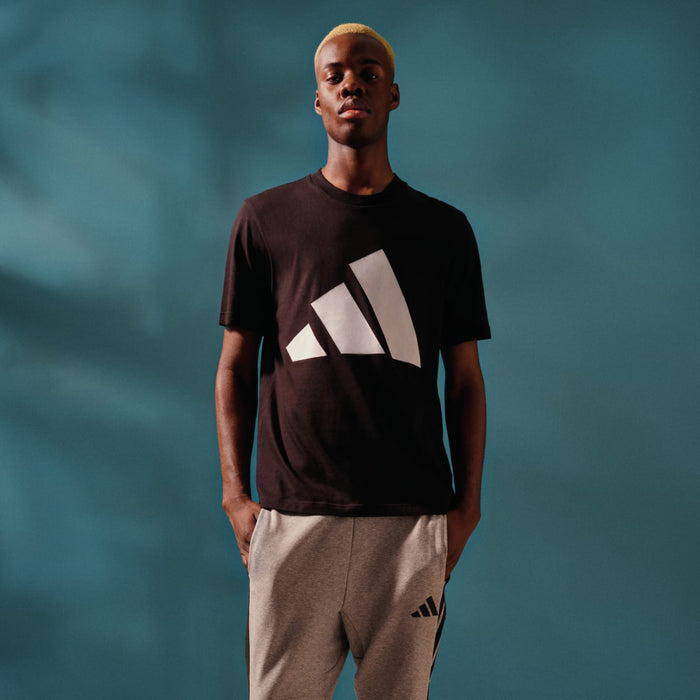 Black crew-neck T-shirt with bold white logo on the front, worn by a model.