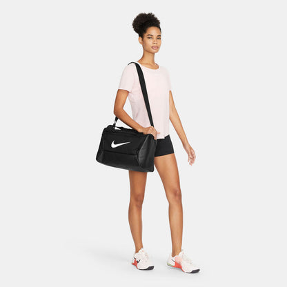Black Nike duffel bag worn crossbody with white swoosh logo