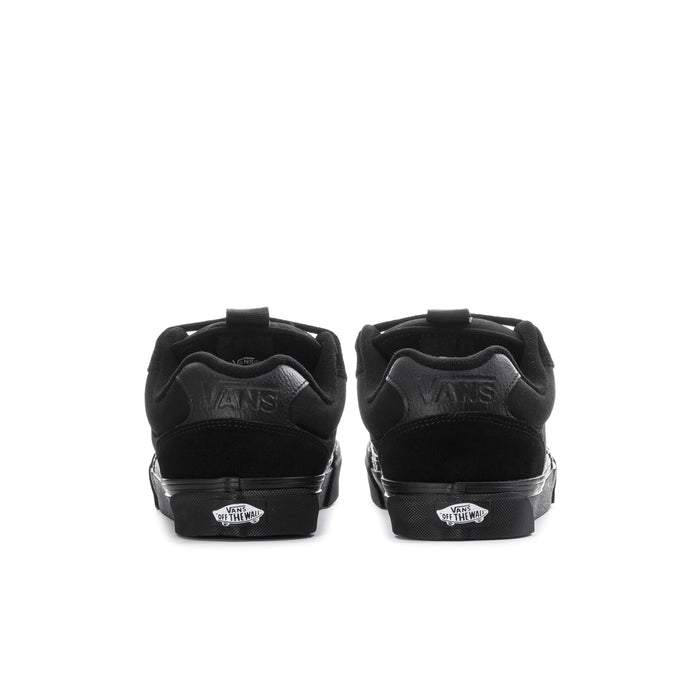 Black chukka-style sneakers showing heel panel with Vans logo details