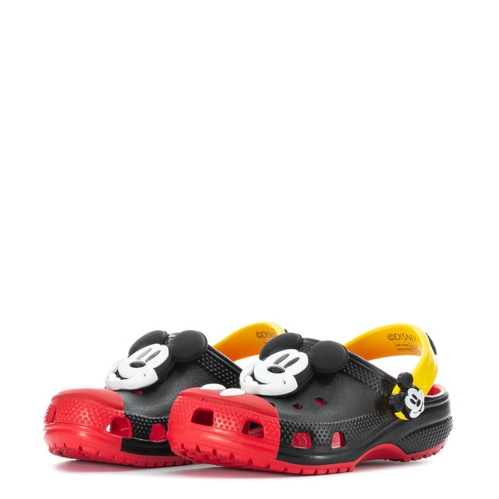 Kids’ black clogs with Mickey head charms, red outsole, and yellow inner lining