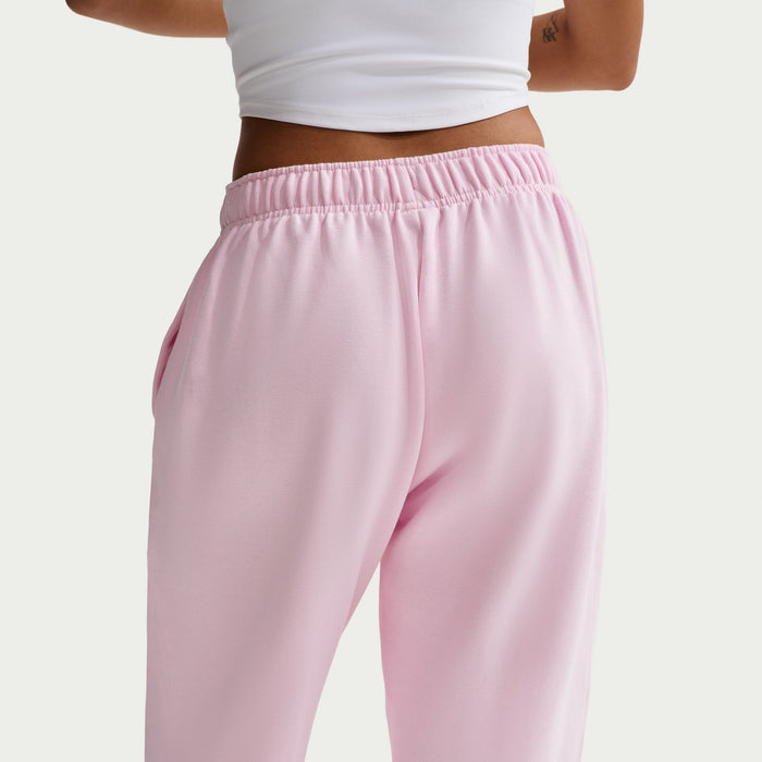 Women’s pink fleece pants close-up: elastic waistband and smooth tapered legs