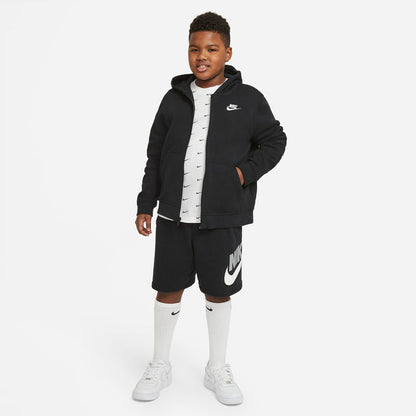 Youth black Nike shorts on model with elastic waistband and white swoosh logo