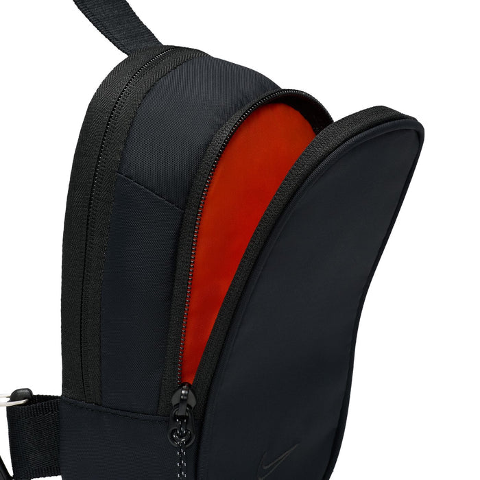 Black crossbody bag with red-lined interior and front zipper opening