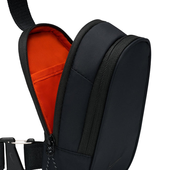 Black crossbody bag with red interior lining and zipper pull detail