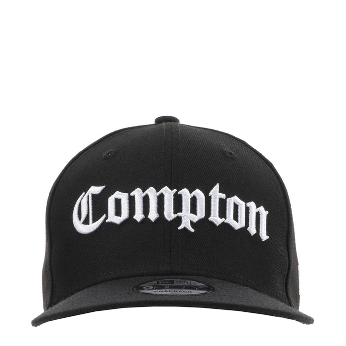 Black baseball cap with white Compton logo on the front panel and curved brim