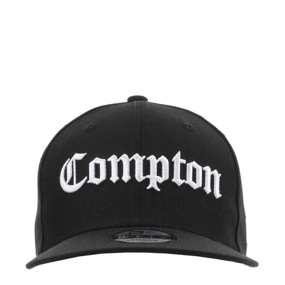 Black baseball cap with white Compton logo on the front panel and curved brim