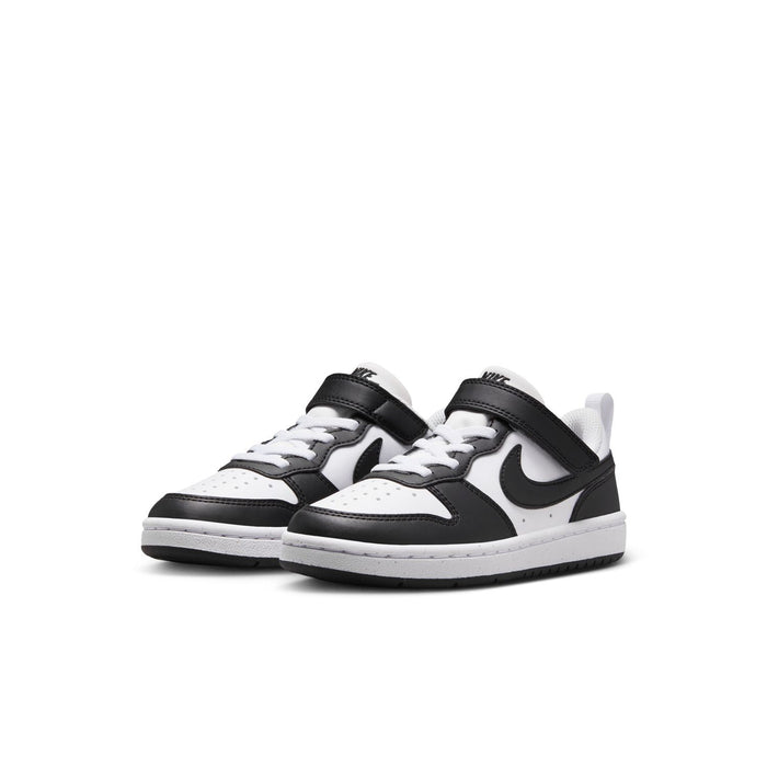 Pair of kids low-top sneakers in white and black with Nike swoosh and lace-up design