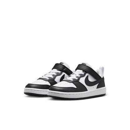 Pair of kids low-top sneakers in white and black with Nike swoosh and lace-up design