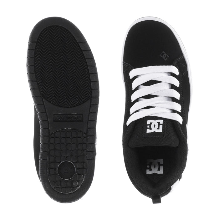 Pair of youth black sneakers showing tread outsole and DC logo on inner side