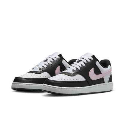 Pair of low-top black and white sneakers with pink side swoosh and white lace-up