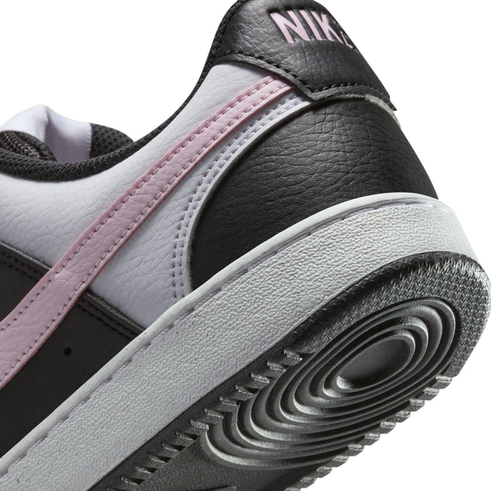 Close-up of low-top sneaker heel and side panel with NIKE logo, pink stripe, textured sole