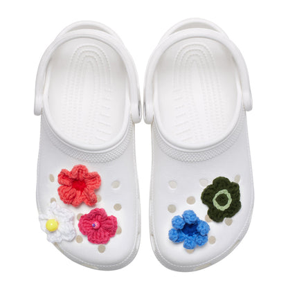 White clogs with crochet floral jibbitz: red, pink, blue, and green flower charms