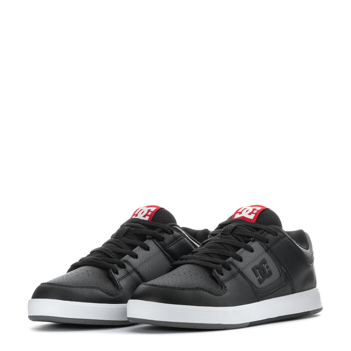 Men's black sneakers, front close-up with twin DC logos and lace-up vamp