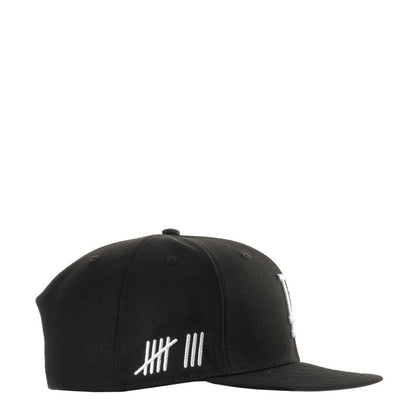 Black baseball cap with white striped graphic on front panel