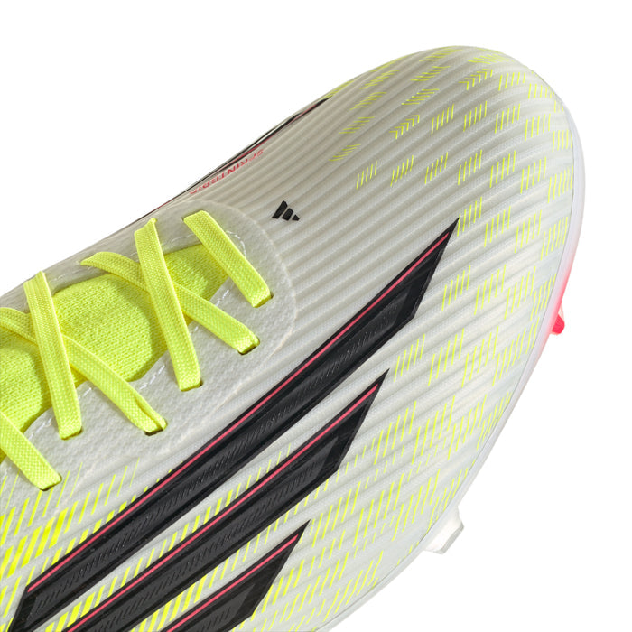 Close-up of neon green cleat upper with black stripe, bright laces, and studs