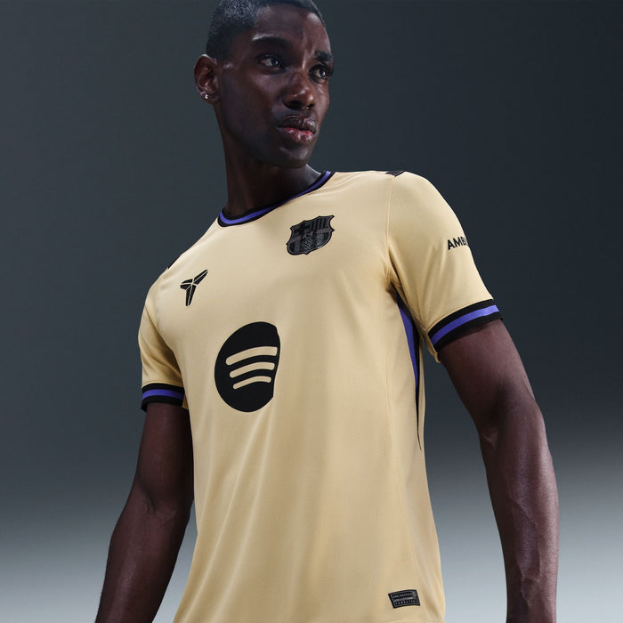 Men's soccer jersey in pale yellow with dark blue trim, FCB crest and circular emblem.