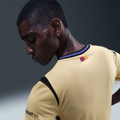 Men's soccer jersey in pale yellow with dark blue trim, sleeve flag patch detail.