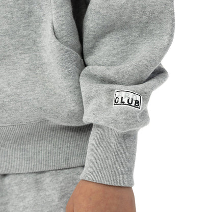 Heather grey hoodie sleeve cuff with 'CLUB' woven logo patch