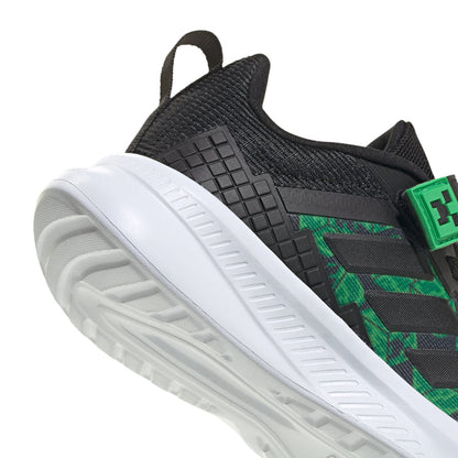 Kids' black sneaker with green logo patch and white treaded outsole