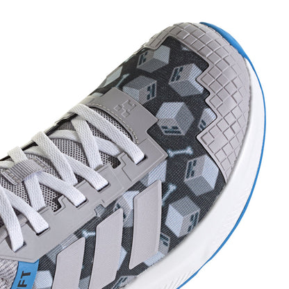 Youth shoe side close-up: gray knit with Minecraft block pattern, white laces, blue edge.