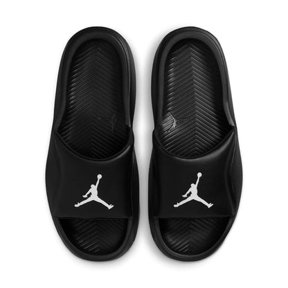 Black slide sandals, white Jumpman logo on strap; textured footbed and outsole