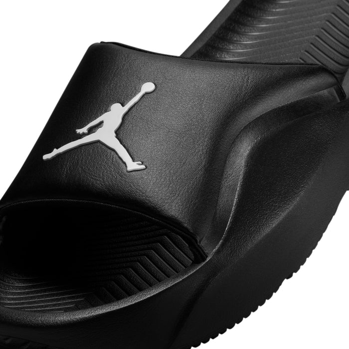 Black slide sandal strap close-up with white Jumpman logo; textured sole